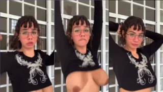 Emo de cabelo comprido mexendo as teta com uma expressão safadinha em um vídeo caseiro